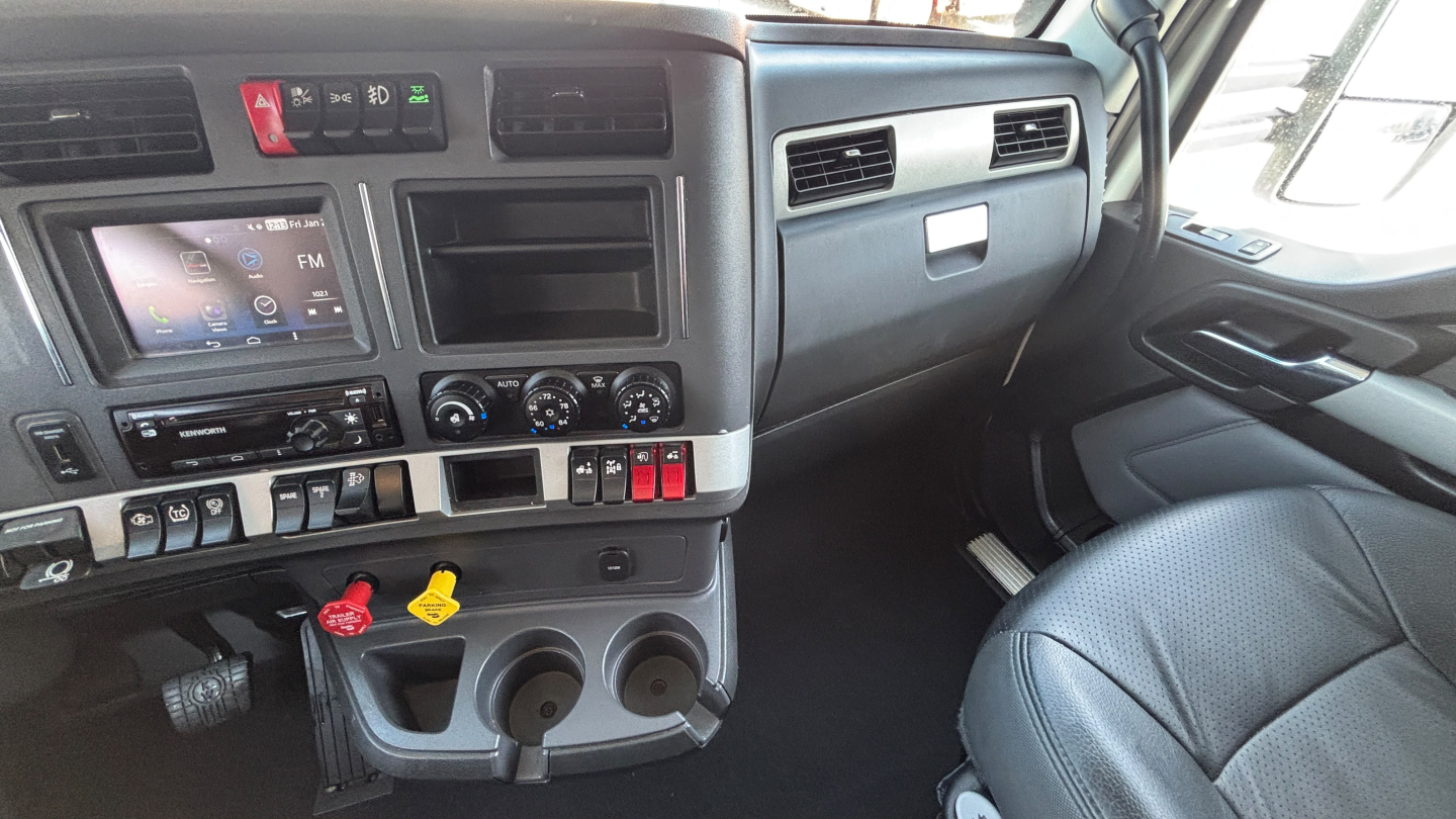 Kenworth T680 cab interior showing dashboard control panel and steering area.