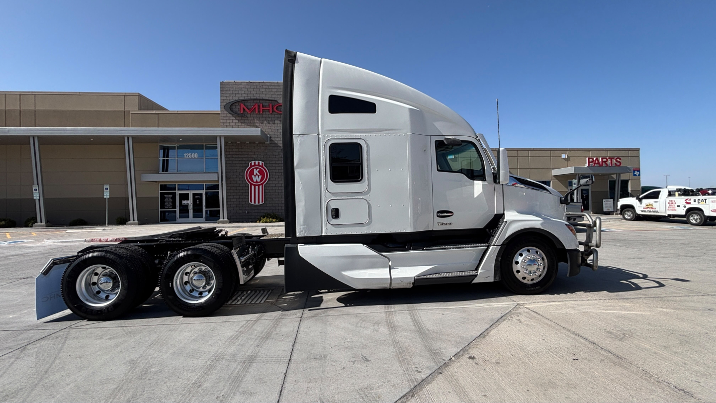 Kenworth T680 highway tractor side view showing sleeper cab and dual rear axles with aluminum fuel tank and chrome mirrors.