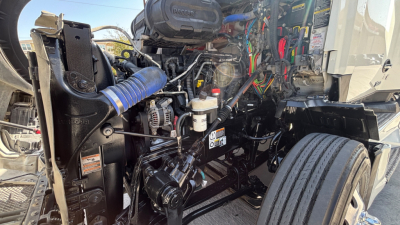 Kenworth T680 engine bay showing exposed components, hoses, and wiring harness in view.