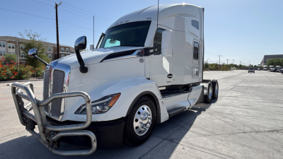Kenworth T680 semi-truck in view showing front grille and aerodynamic cabin with chrome bumper guard.