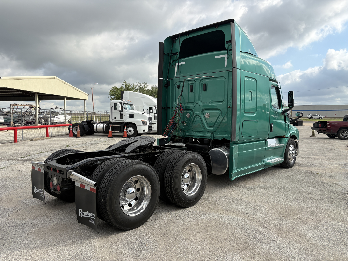 Freightliner Cascadia 126 tractor-trailer rear and cab view showing dual rear axles and green exterior.