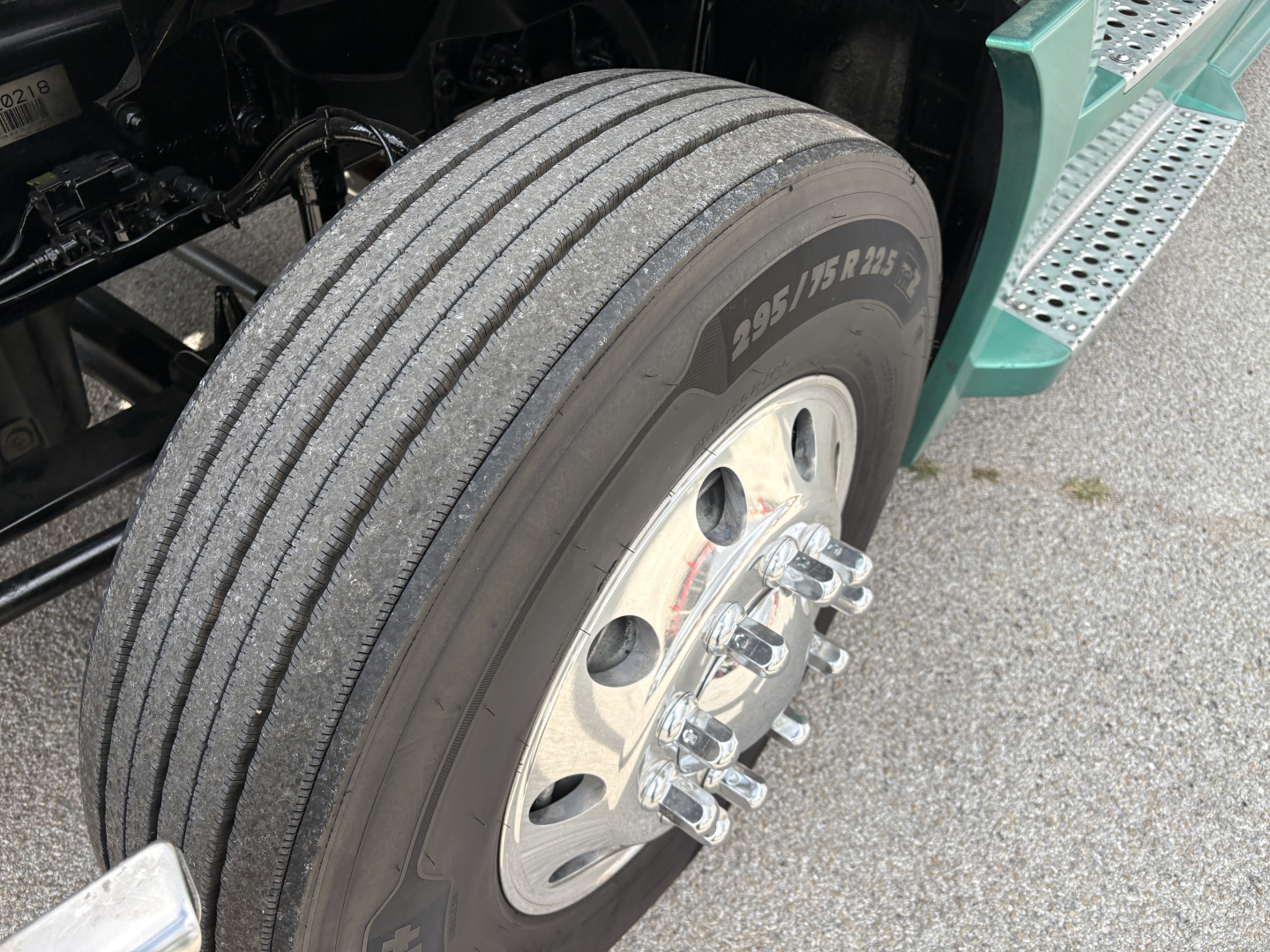 Truck wheel and dual rear tires of a Freightliner Cascadia 126 in-service showing 275/80R22.5 tire and polished dual wheel hub with lug nuts.