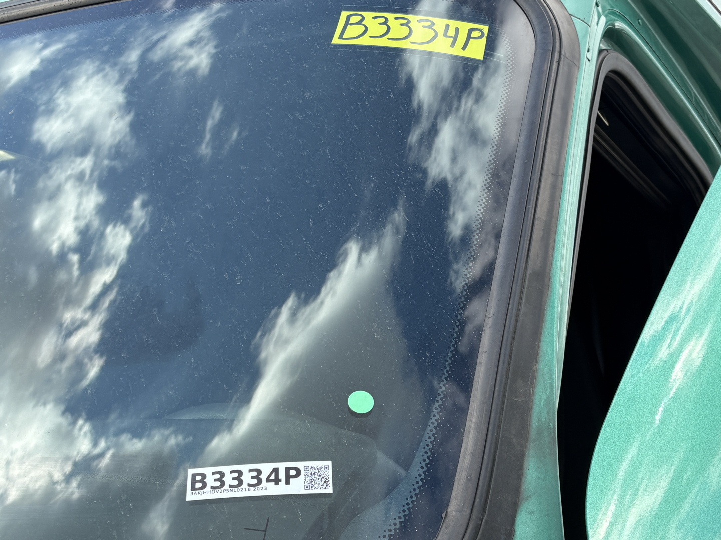 Truck windshield with yellow B3334P label and B3334P sticker visible on Freightliner Cascadia cab door area