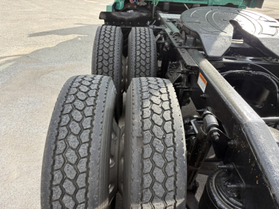 Two rear truck axles with dual tires and a metal frame, showing the wheel ends and suspension components.