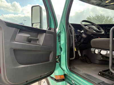  Freightliner Cascadia 126 cab interior with open driver door showing steering wheel and dash. 