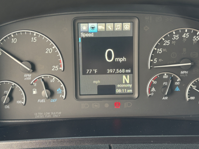 Cab dashboard of a Freightliner Cascadia 126 showing digital display with speed 0 mph, 397,568 miles, gear N, and temperature 77°F.