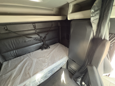 Freightliner Cascadia 126 sleeper cab interior with bunk bed and window shade visible.