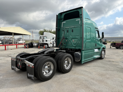 Freightliner Cascadia 126 tractor-trailer rear and cab view showing dual rear axles and green exterior.