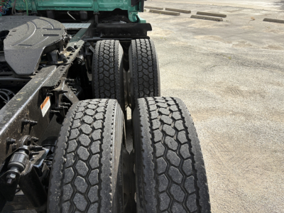 Freightliner Cascadia 126 truck rear dual rear axles with tires, chassis and fuel/air components visible in an outdoor lot.