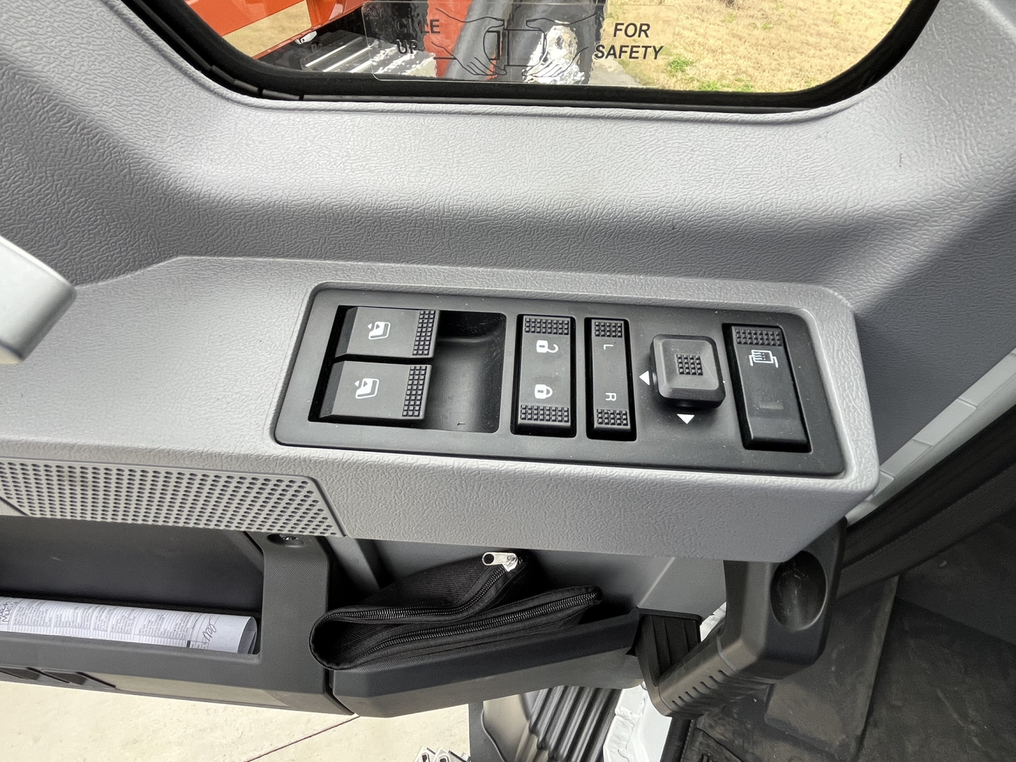Truck interior door panel controls with window switches and memory/lock buttons; dashboard and mirror controls visible.