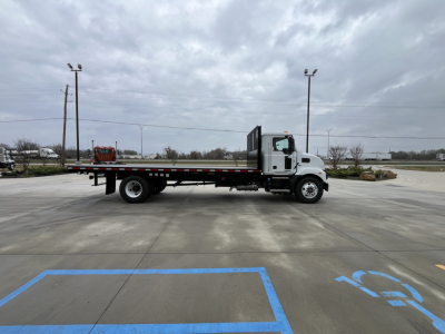 Mack MD6 flatbed truck side view showing cab and long flatbed.