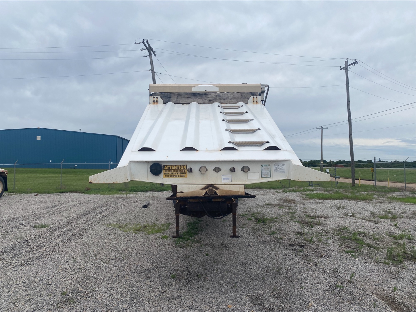 Dump trailer rear with Armor Lite SBD40 skeleton; view shows top ribbed bed, rear bumper, and safety decals