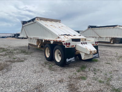 Dump trailer showing white Armor Lite SBD40 skeleton bed with dual rear axles and mud flaps.