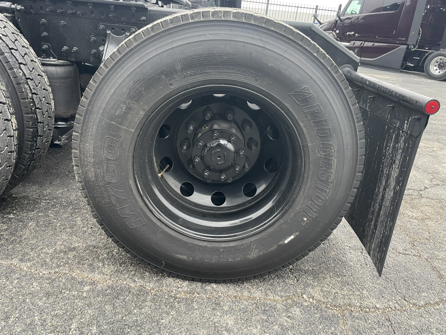 Truck wheel and fender of a Mack PR64T76H showing a large radial tire mounted on a steel wheel.