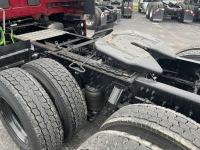 Chassis and dual rear axles of a Mack truck tractor showing fifth wheel, air suspension, and rear tires.