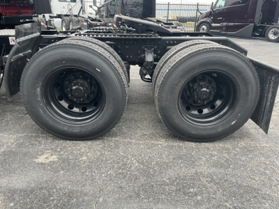 Two rear axles of a Mack PR64T76H truck showing dual-drive wheels and suspension components.