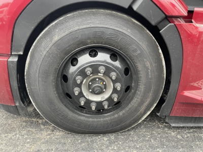 Mack PR64T76H truck front wheel showing tire with R265/80(?) G load rating and wheel lug nuts.