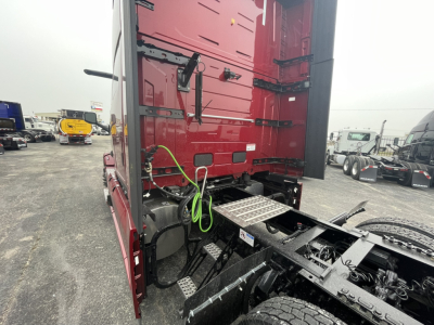 Mack PR64T76H tractor cab rear view showing green air lines and chassis components under sleeper area.