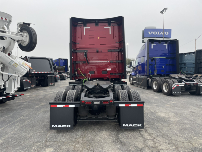 Mack PR64T76H tractor with fifth-wheel area and rear view, red cab-back section, dual rear axles, Mack mud flaps, in a truck yard.