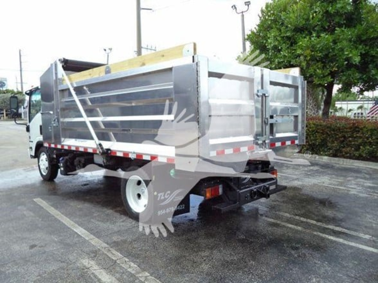 Isuzu NPR XD dump truck rear view showing metal dump bed and rear bumper