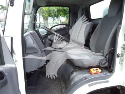 Isuzu NPR Xd cab interior showing driver's seat and passenger seat, steering wheel, dashboard, floor mat, and a small orange device in the footwell.