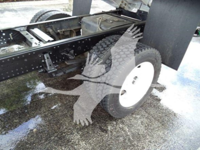 Isuzu NPR XD chassis view showing rear wheel and frame with leaf springs and undercarriage components.
