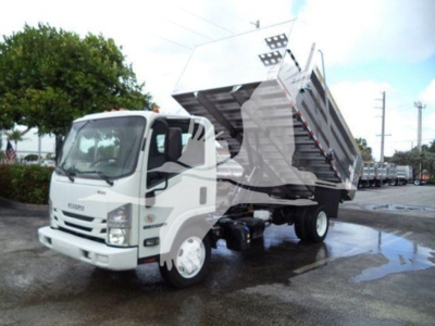 Isuzu NPR XD dump truck side view showing tipped cargo bed and hydraulic lift in operation.