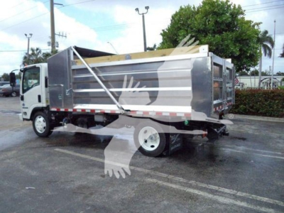 Isuzu NPR XD dump truck rear/side view showing silver dump bed with reflective safety stripes and label panels.