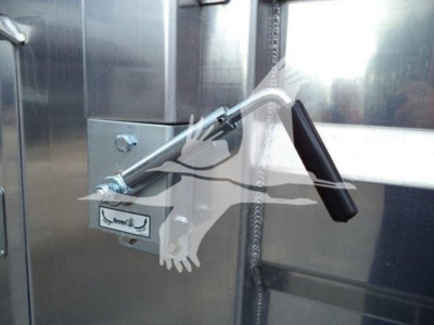 Lever and latch mechanism on metal surface with chain torsion and black handle.