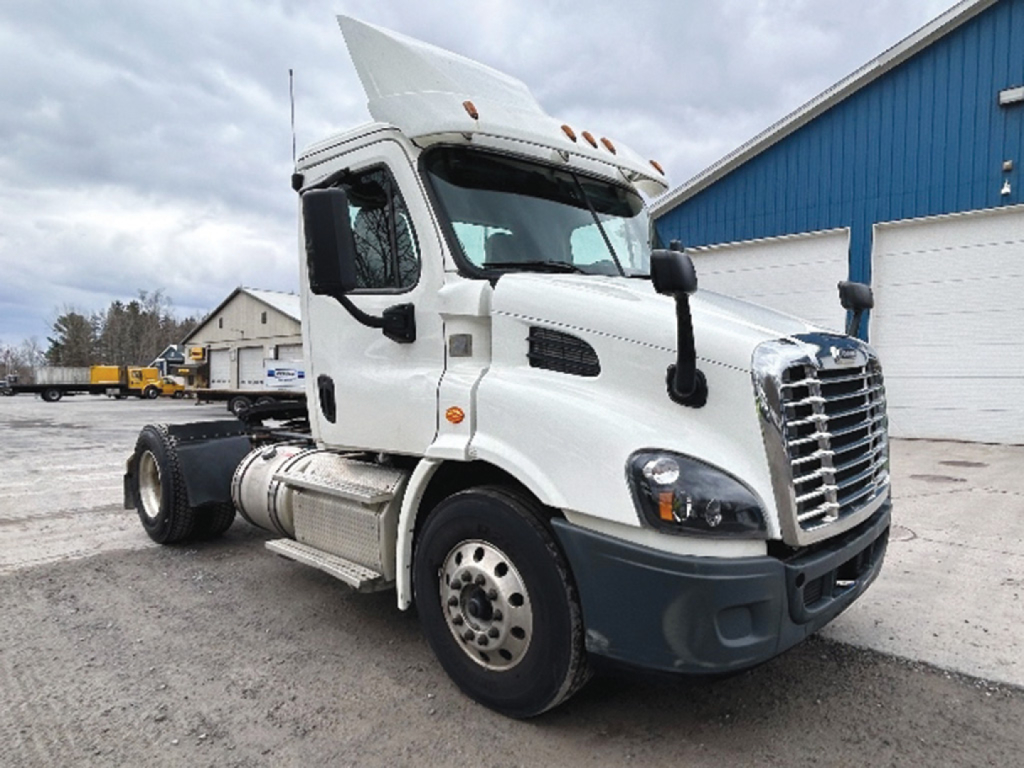 Truck cab side with raised hood, Freightliner Cascadia 113 day cab, front grille, side mirrors, fuel tanks, and chassis.