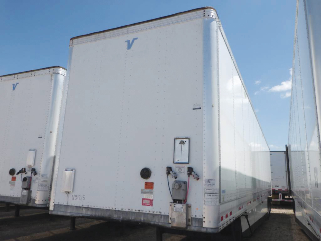 Trailer van with rear doors and hydraulic lift under a Vanguard logo; white exterior with reflective tape.