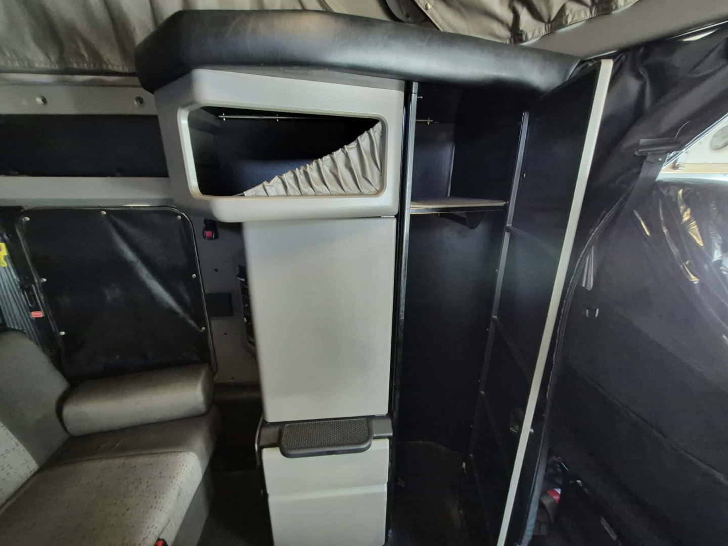 Kenworth W900L cabin interior showing driver seat, center console with storage, and side cabinet panels