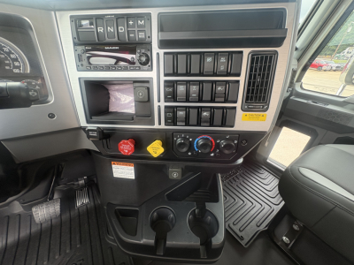 Truck cab dashboard showing control panel with R N D P gear indicator, climate controls, auxiliary switches, cigarette lighter, USB, storage pocket, cup holders, and floor mats.