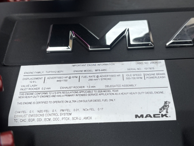 Mack PI64T engine bay badge area with model name and engine information plate listing engine model, fuel rate, idle speed, exhaust, and serial details.