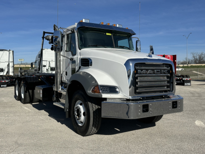 Mack GR64B roll-off truck in white and chrome showing front grille with Mack logo and heavy-duty bumper.