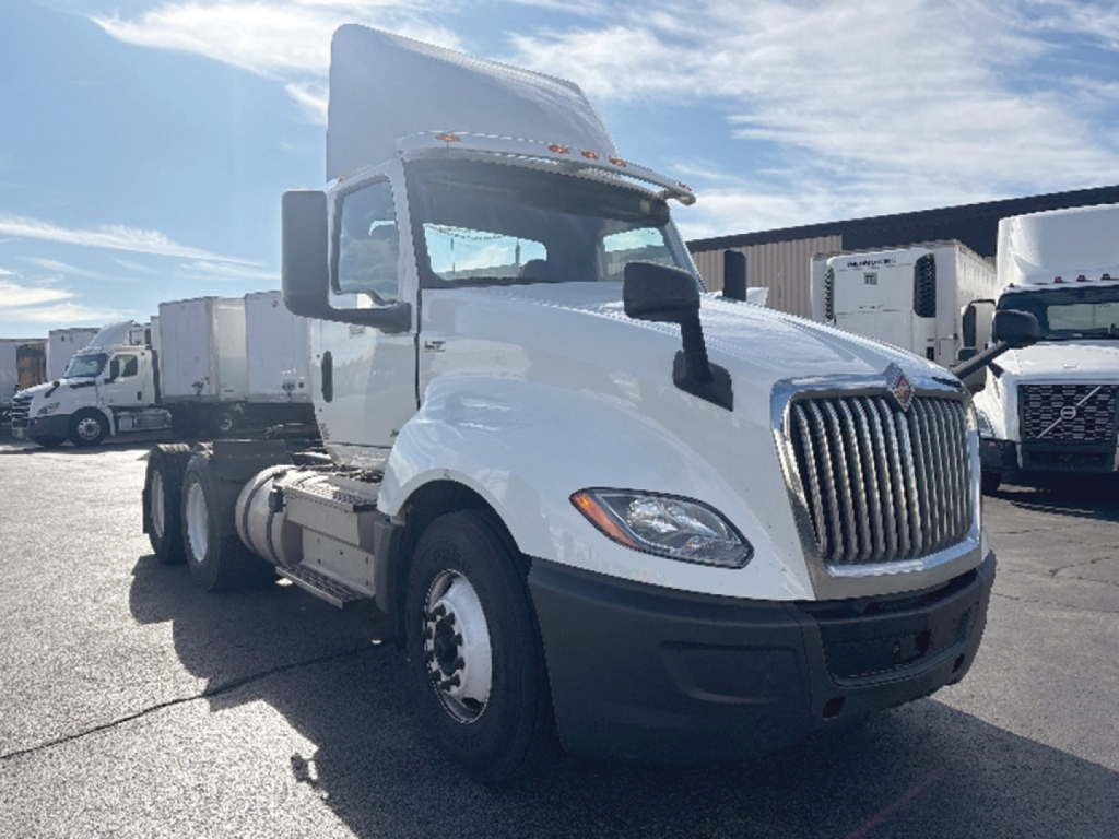 International LT625 conventional daycab truck in view showing cab and front grille with white body and black bumper.