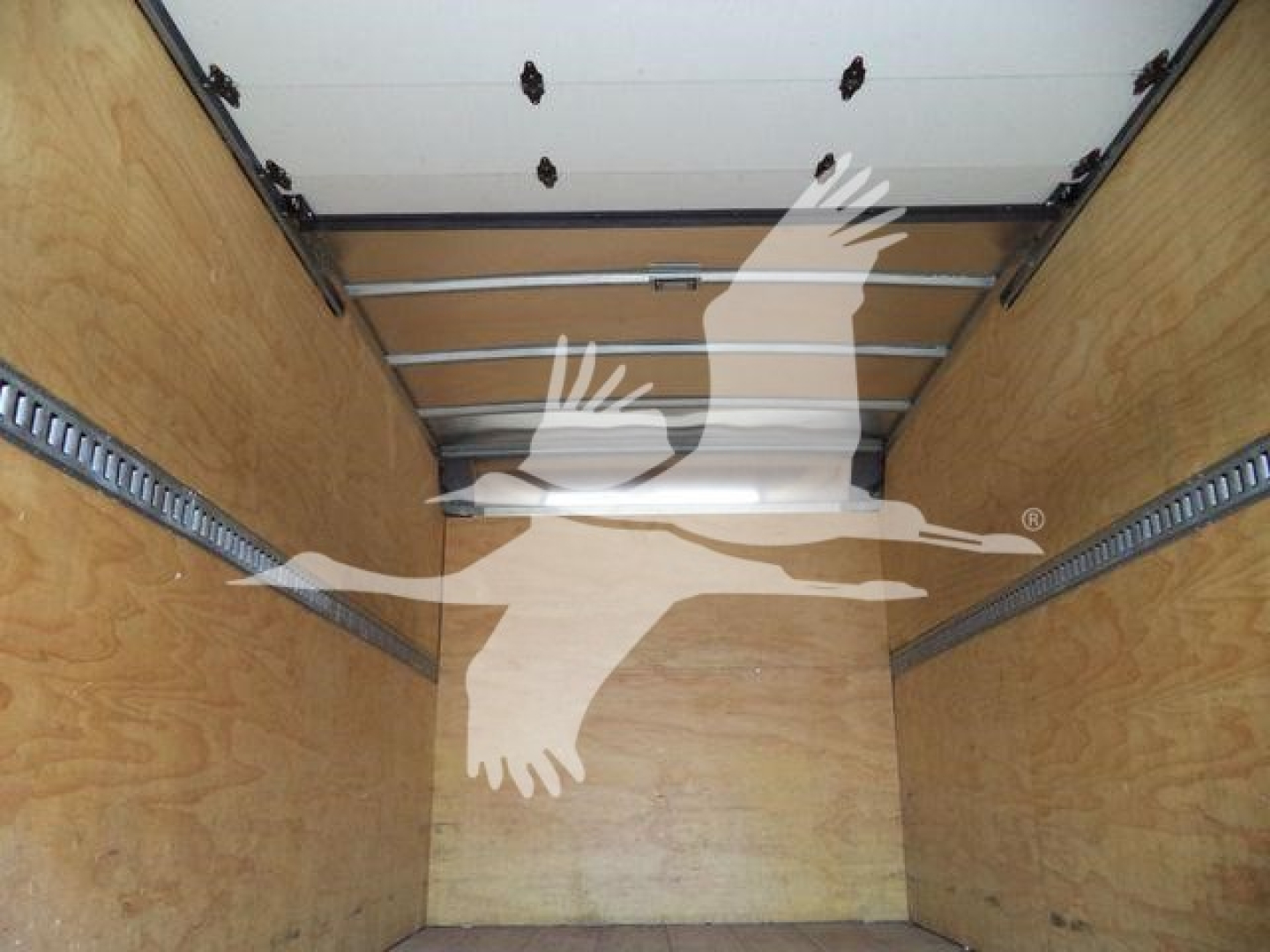 Box truck cargo area of a 2019 Isuzu NPR/NRR with wooden side walls and metal rails, empty cargo space visible.