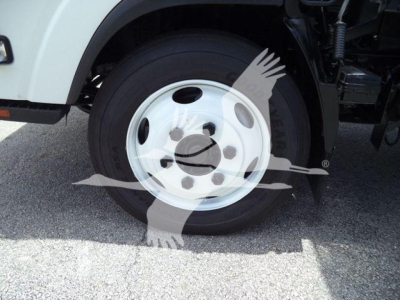 Isuzu NPR/NRR front wheel area showing wheel and tire with partial underbody components visible.