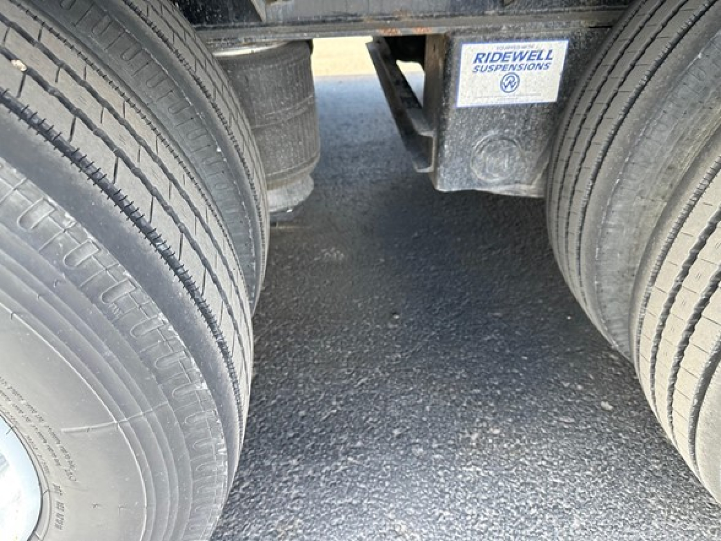 Trailer rear axles with dual tires and Ridewell suspensions sticker visible between wheels.