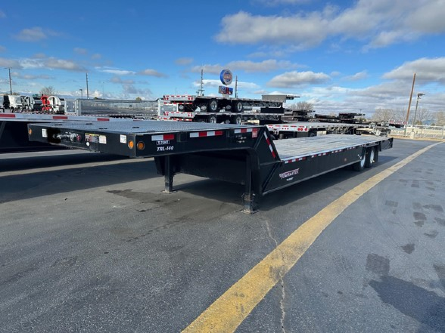 Trail King 7-70Ht traveling axle trailer in-use condition showing flatbed and dual rear axles.