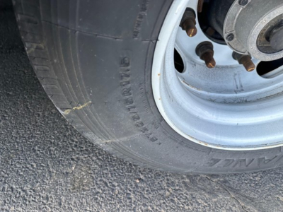 TrailKing 7-70HT trailer wheel and tire showing steel rim and lug nuts.