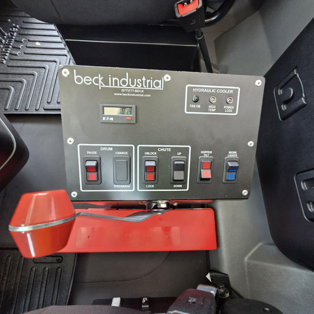 Beck Industrial control panel in Mack mixer cab showing hydraulic cooler switch panel with pause, drum, unload, and lock/down controls.