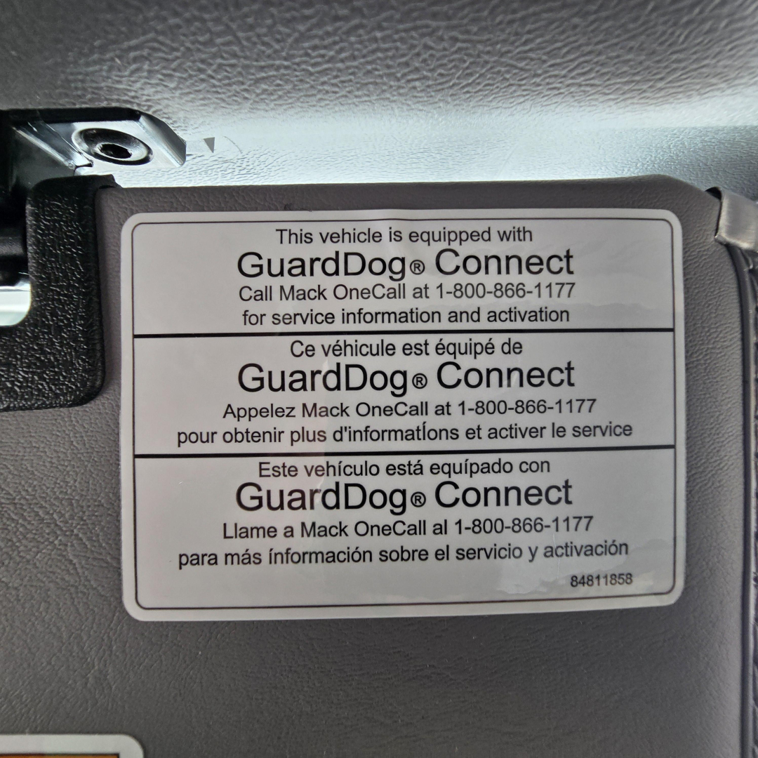 GuardDog Connect label on Mack GR64B showing bilingual instructions and activation phone number.