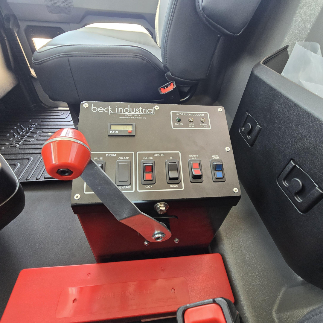 Beck/Industria control panel in Mack GR64B mixer truck cab showing levers and switches with labels, red knob, and seating areas.