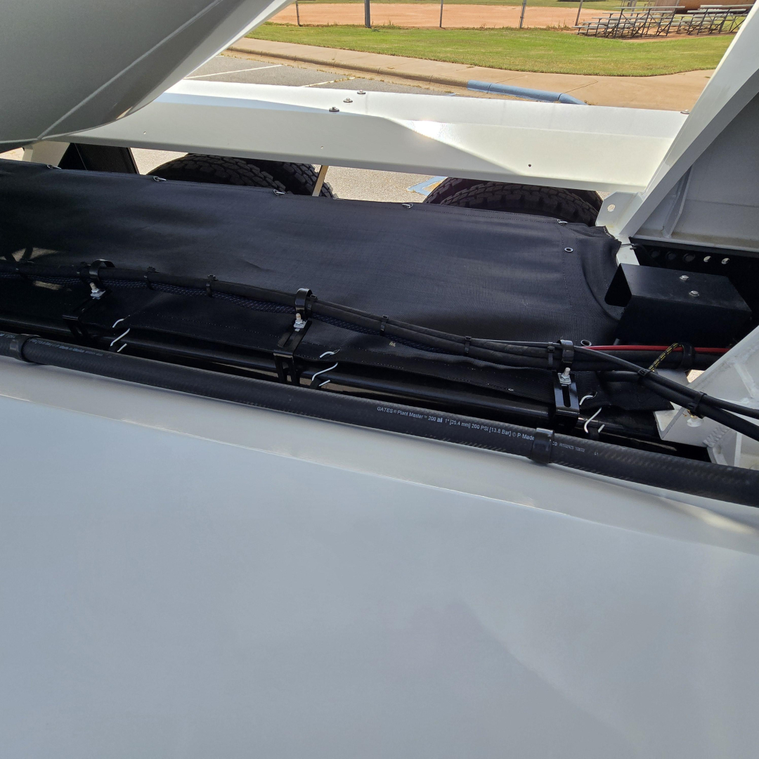 Mack GR64B mixer truck bed interior showing hydraulic hose lines and solar of equipment
