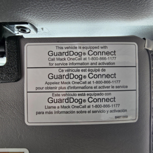 GuardDog Connect label on Mack GR64B showing bilingual instructions and activation phone number.