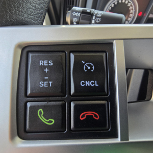 Mack truck steering wheel and multi-function control buttons showing RES and CNCL cruise controls and green/red phone icons