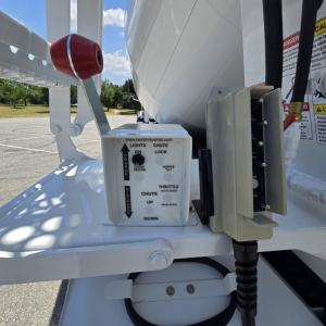Mixer truck hitch area showing control box and lever with labels: BECK INDUSTRIAL lights on/off arrow, choke, up, down; adjacent hydraulic controller and hydraulic hose reel.