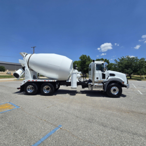 Mixer truck with white cement mixer body and cab, 6-wheel configuration, side view, in a parking lot.