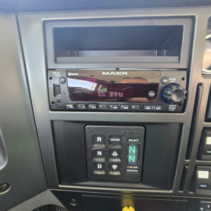 Mack GR64B interior dash showing aftermarket stereo head unit and gear selector panel with R N D positions.